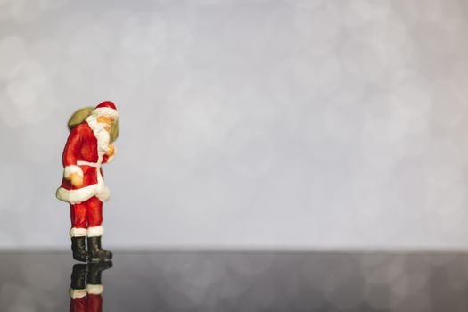 Miniature people : Santa Claus carrying bag  on bokeh  background , Merry Christmas and Happy New Year concept.