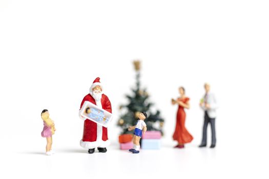 Miniature people : Santa Claus holding gift for happy family , Christmas and Happy New Year concept.