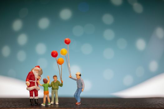 Miniature people: Santa Claus and children holding balloon , Merry Christmas and Happy New Year concept.