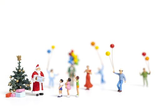 Miniature people : Santa Claus holding gift for happy family , Christmas and Happy New Year concept.