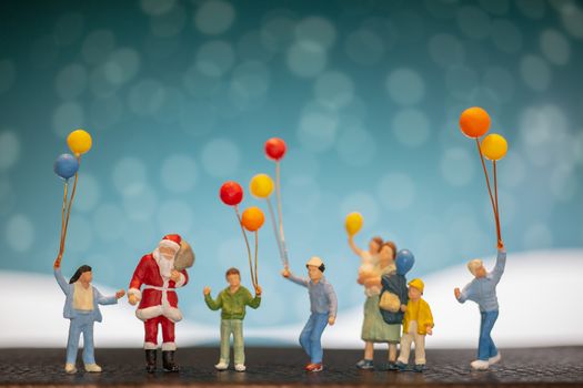 Miniature people: Santa Claus and children holding balloon , Merry Christmas and Happy New Year concept.