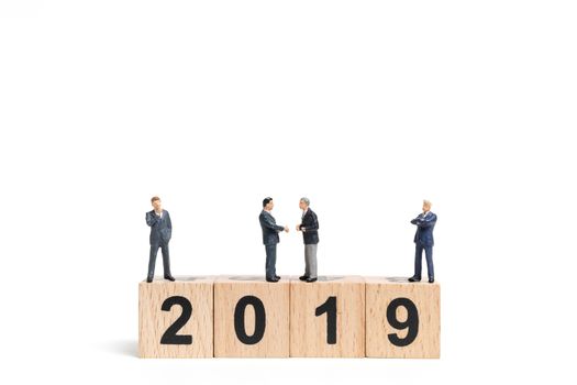 Miniature people : businessman  standing and thinking on wooden block number 2019. on white background