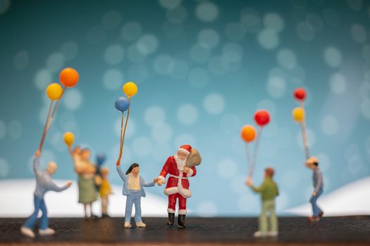 Miniature people: Santa Claus and children holding balloon , Merry Christmas and Happy New Year concept.