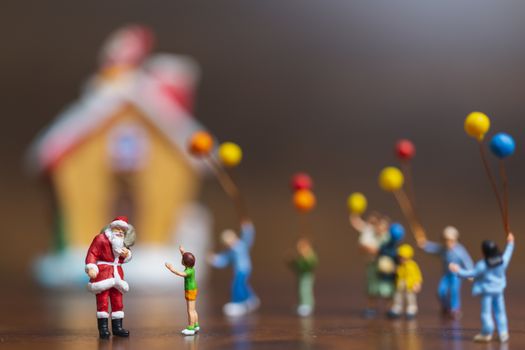 Miniature people: Santa Claus and children holding balloon , Merry Christmas and Happy New Year concept.