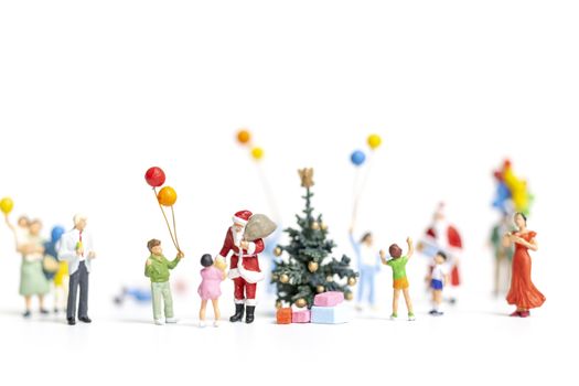 Miniature people : Santa Claus holding gift for happy family , Christmas and Happy New Year concept.