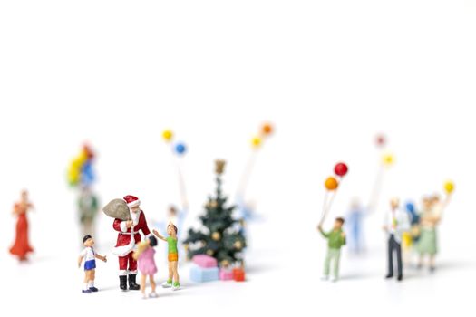 Miniature people : Santa Claus holding gift for happy family , Christmas and Happy New Year concept.