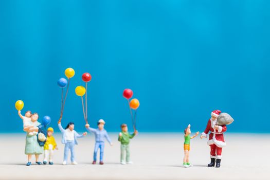 Miniature people: Santa Claus and children holding balloon , Merry Christmas and Happy New Year concept.