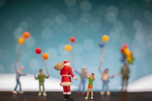 Miniature people: Santa Claus and children holding balloon , Merry Christmas and Happy New Year concept.