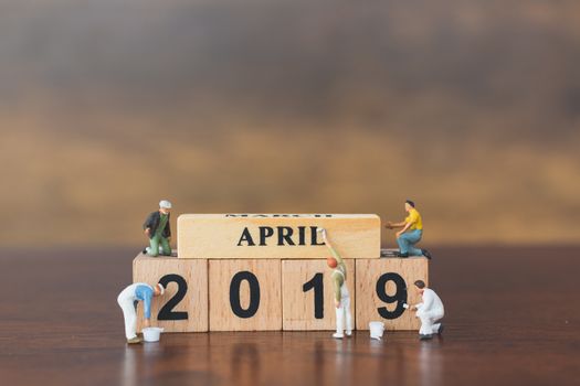 Miniature worker team painting  on wooden block , Happy new year 2019 concept