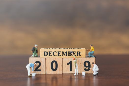 Miniature worker team painting  on wooden block , Happy new year 2019 concept