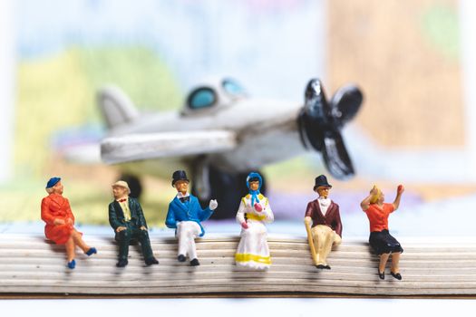 Miniature people sitting on The Airplane with world map background, Travel concept