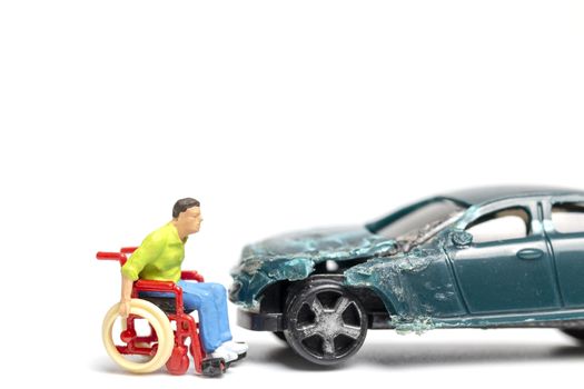 Miniature people : Man on wheelchair and car wreck , Don't drink and drive concept.