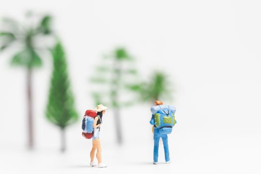Miniature people : Traveler with backpack walking on whitebackground , Travel and Adventure concepts.