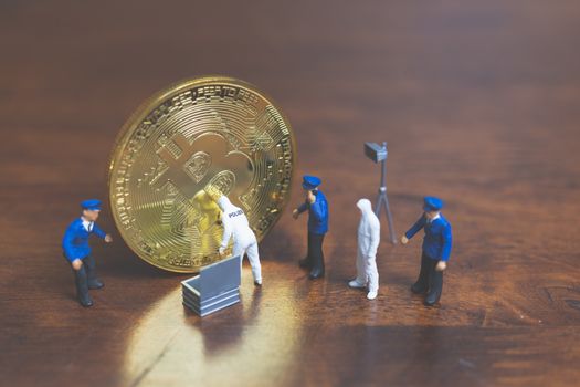 Miniature people : Police And Detective standing in front of Cryptocurrency bitcoin , Cyber crimes concept