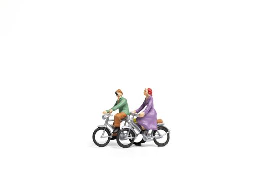 Miniature people : Couple ride bicycle on white background , Valentine's Day concept