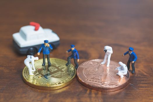 Miniature people : Police And Detective standing in front of Cryptocurrency bitcoin , Cyber crimes concept