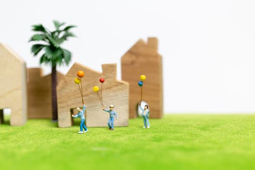 Miniature people : Happy family walking in field with balloons ,   Happy family relations and carefree leisure time Concept