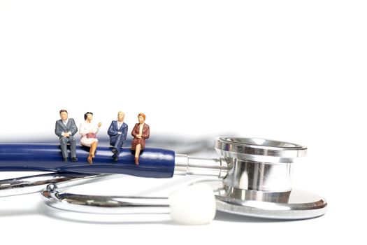 Miniature people sitting on a stethoscope on white background , Health care  concept