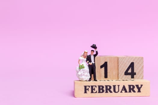 Miniature people wedding , bride and groom couple on pink  background , Valentine's Day concept