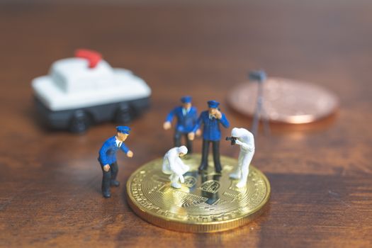 Miniature people : Police And Detective standing in front of Cryptocurrency bitcoin , Cyber crimes concept