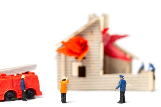 Miniature people : Firefighters with water pistols are taking care of a fire emergency