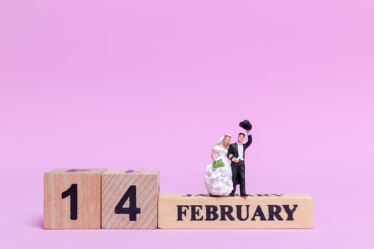 Miniature people wedding , bride and groom couple on pink  background , Valentine's Day concept