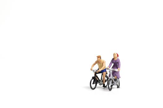 Miniature people : Couple ride bicycle on white background , Valentine's Day concept