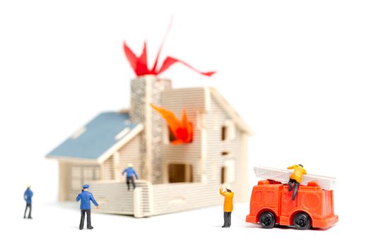 Miniature people : Firefighters with water pistols are taking care of a fire emergency
