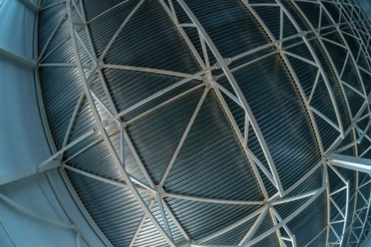 A heavy distortrd fish-eye lens picture of industrial ceiling with supporting beam construction frame and profiled sheets. Zenith direction of view.