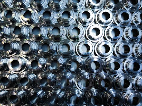 a batch of shiny metal cnc aerospace parts production - close-up with selective focus for industrial background in flat lay composition