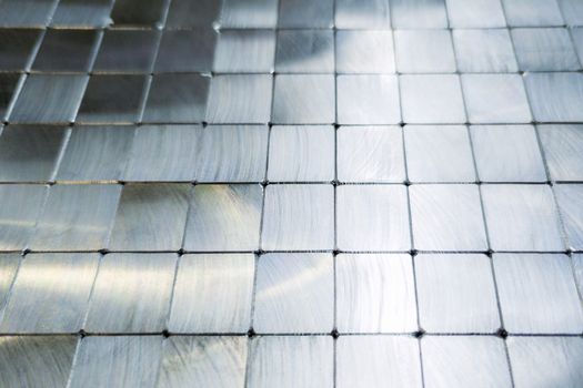 shiny steel machined blocks pavement surface background - close-up with selective focus and blur.