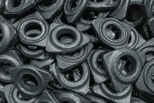 heap of grey steel forgings after shot blasting - close-up natural heavy industrial pattern with selective focus and grim mood