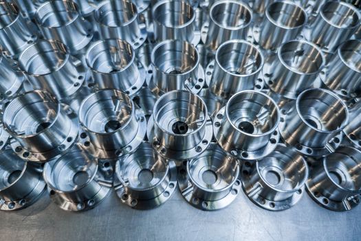 a batch of shiny metal aerospace parts production made with cnc machines - close-up with selective focus for industrial background