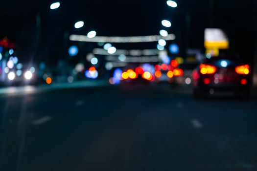 Defocused picture of night street car traffic - view from road. Colorful night life dark background.