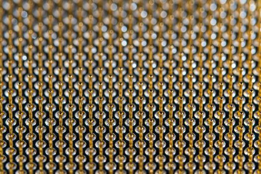 Close-up full frame view of gold plated microprocessor pin array. Abstract electronic technological background with selective focus.