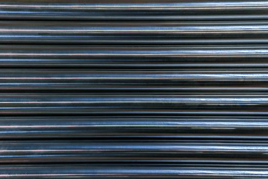 abstract industrial background of shiny cnc turned rods with flat lay in simple horizontal parallel geometric pattern