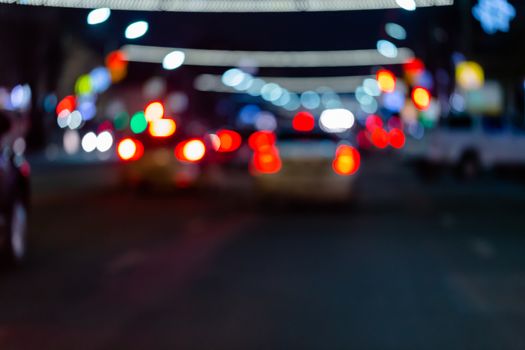 Defocused picture of night street car traffic - view from road. Colorful night life dark background.