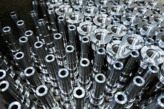 Shiny steel parts close-up background, long clean steel rods after fine cnc turning.