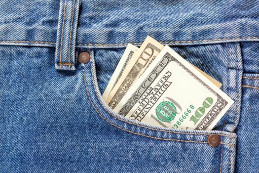 US dollar banknotes in the right front pocket of blue jeans. Concept of saving money or pocket expenses.