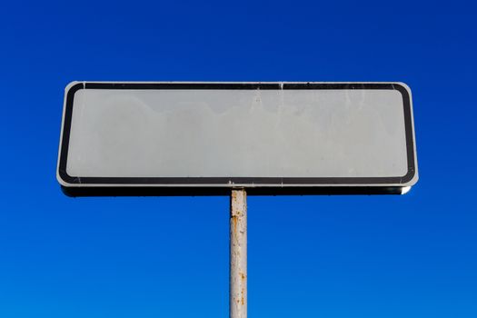 a small white road sign mockup on blue sky background. Place for tour text.