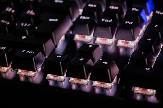 a close-up view of black mechanical pc keyboard with white backlight.