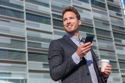 Office work man looking away businessman holding mobile cell phone. Young urban professional man using smartphone at office building. Career job opportunity concept.