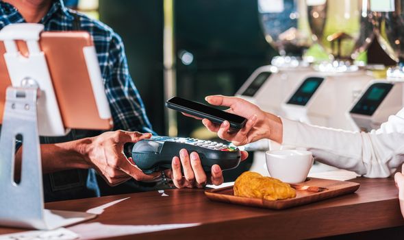 Closeup Asian customer man hand paying money via contactless channel by mobile banking application to Small business owner at table in cafe shop, Small business owner and startup in coffee shop