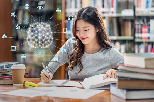 Polygonal brain shape of an artificial intelligence with various icon of smart city Internet of Things Technology over Asian young Student in casual suit reading the book in library of university