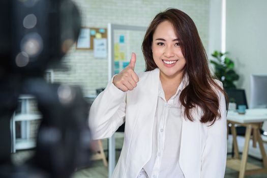 Portrait of Asian Business woman with thumbs up like when recording video for social influence at modern workplace,
human resource and small business owner, vlogging and social network concept