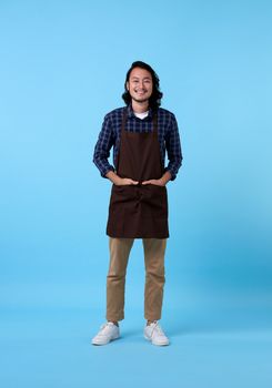 Portrait of service minded handsome asian man employee studio shot on blue background