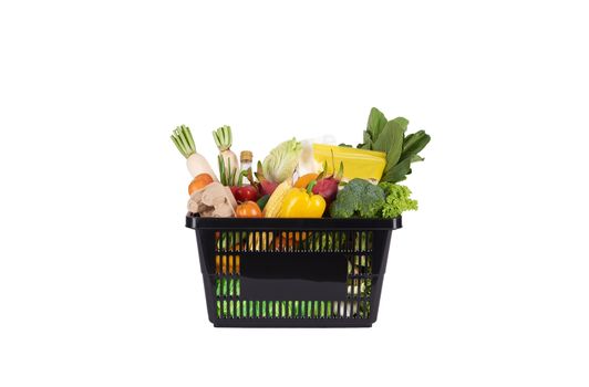 Black plastic grocery basket full of healthy vegetables and fruits,  ingredients isolated on white background