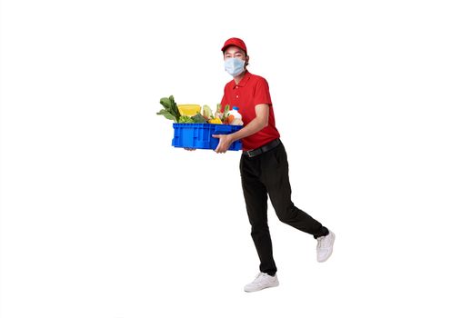 Asian delivery man wearing face mask in red uniform holding fresh food basket isolated over white background. express delivery service during covid19.