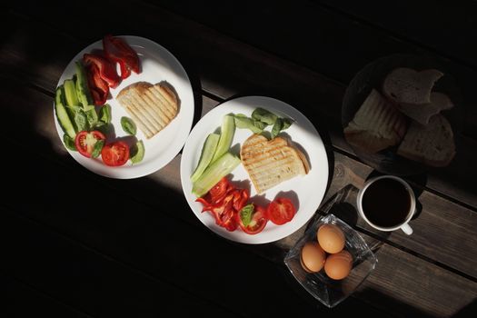 Healthy organic vegetable breakfast, tomato, toast, salad, basil, egg, coffee. Vegetarian healthy food in a white plate on a dark wooden table. High quality photo