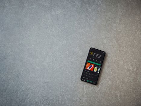Lod, Israel - July 8, 2020: Adobe Spark Post - Graphic Design and Story Templates app play store page on the display of a black mobile smartphone on ceramic stone background.Top view flat lay with copy space